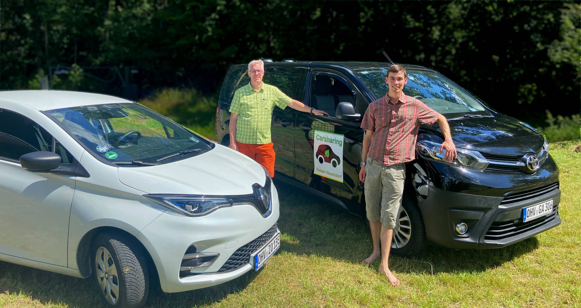 Renault Zoe und Toyota Proace des Vereins auf einer Wiese, davor zwei Personen